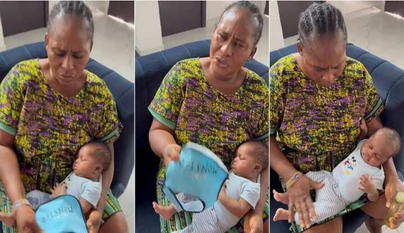 Scared Nigerian Grandma Displays Words Written On Newborn Baby's Bib in Video image